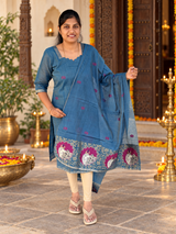Blue festive salwar suit with printed cow motif border and matching dupatta, front view